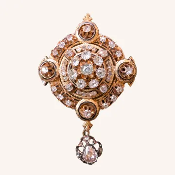 Broche circular dorado con pedrería y colgante