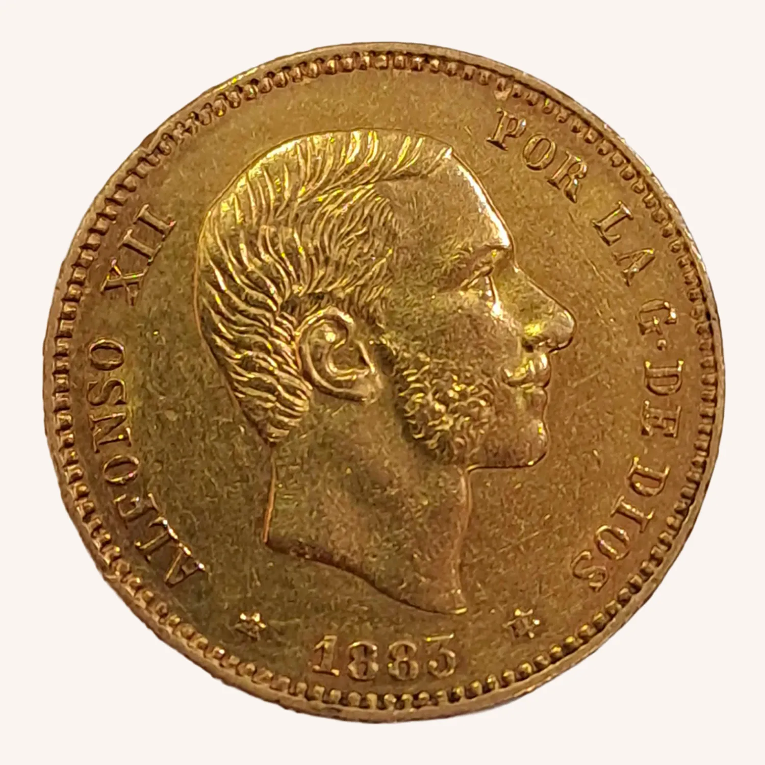 Moneda dorada de 1885 con retrato masculino de perfil