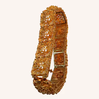 Pulsera dorada articulada con decoración floral vista de lado